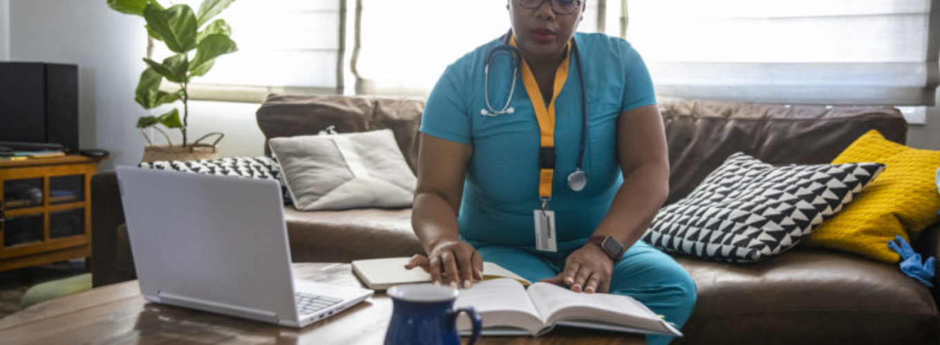 A black female nurse studying for another degree studies between her shifts